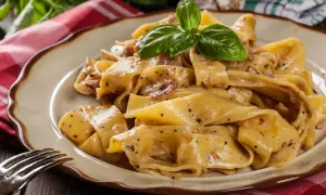 Cremige Pappardelle mit Speck und Kräutern, ein köstliches Pappardelle Rezept, garniert mit frischem Basilikum.