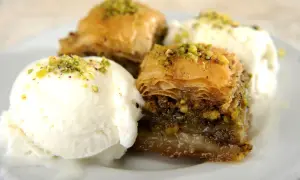 Délicieux baklava recette servi avec de la glace à la vanille, saupoudré de pistaches concassées.