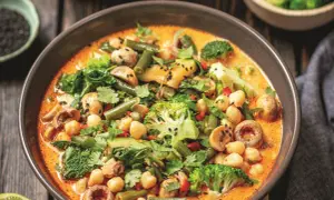 Aksamitne curry z ciecierzycy z brokułami, fasolką szparagową i grzybami, posypane czarnym sezamem.
