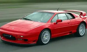 Röd Lotus Esprit, ett ikoniskt sportbilmärke, kör på en asfalterad väg.