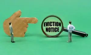 Dito un dito di cartone indica una lente d'ingrandimento con la scritta "EVICTION NOTICE". Un omino guarda la lente, suggerendo un imminente sfratto per finita locazione e canoni non pagati.