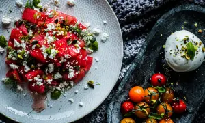 Salade de pastèque, feta, pistaches et tomates cerises, avec une burrata crémeuse. Un délice estival qui rappelle la tomate mozzarella.