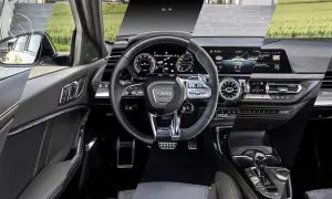 Interni moderni dell'Audi A3: volante sportivo, cruscotto digitale e console centrale con cambio automatico.