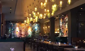 Mysig restaurang i Berlin med många vackra lampor och en färgglad vägg. Perfekt för en middag på en av Berlins bra restauranger.