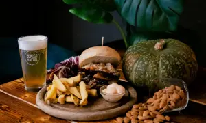 Hamburger, patatine e birra artigianale: un perfetto abbinamento cibo birra. Zucca e mandorle completano la scena.