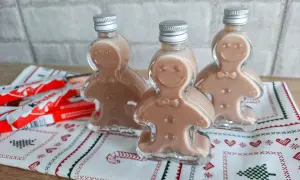 Trzy buteleczki likieru w kształcie ludzików z piernika, obok batoniki Kinder.