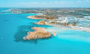 En livlig strand med turkost vatten, solbadande och vattensporter. Perfekt för Ayia Napa aktiviteter.