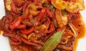 Ein saftiges Paprikaschnitzel-Rezept mit geschmortem Paprika, Zwiebeln und Pilzen, garniert mit einem Lorbeerblatt.