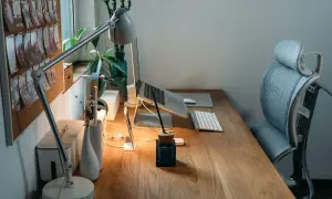 Bureau en bois avec plan de travail, ordinateur portable, lampe, clavier et chaise ergonomique. Une idée d'espace de travail fonctionnel et esthétique.
