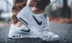 Białe buty sportowe Nike z czarnym logo. Dobre wsparcie dla stóp, idealne jako buty przy zapalenie rozcięgna podeszwowego.