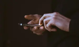 Mains utilisant un smartphone, frustrées par une application qui se ferme toute seule sur Android.