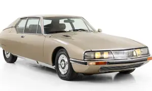 En beige Citroën SM, en av många ikoniska Citroën modeller, med sina distinkta linjer och strålkastare.