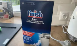 Pudełko soli do zmywarki Finish na blacie kuchennym.