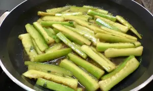 Tranches de concombre cuit dans une poêle, prêtes pour une recette savoureuse.