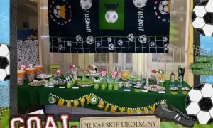 Stół z przekąskami na urodziny piłka nożna. Dekoracje w kształcie piłek, baner "Happy Birthday" i tort w kształcie piłki.
