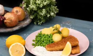 Panerad fisk med kokt potatis, gröna ärtor och en krämig sås som påminner om skolans kalla fisksås. Serveras med citron.