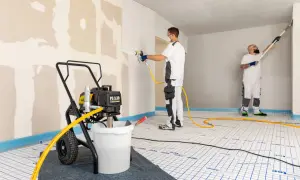 Appareil de projection airless pour enduit et peinture, utilisé par des peintres en bâtiment pour un travail de finition impeccable.