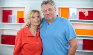 Krzysztof Cugowski z żoną, Beatą, pozują do zdjęcia na tle kolorowych półek.