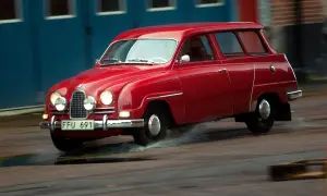 Röd Saab 2-takt kombi kör genom vattenpölar.