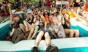 A group of friends enjoys a ball pit at the lil dub festival, laughing and posing for a photo.