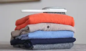 Ein Stapel bunter Kaschmirpullover, bereit für die Pflege. Was ist Kaschmir? Weiche Wolle für luxuriöse Kleidung.
