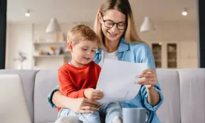 Mama z synkiem aktywnie w domu dla kogoś, przeglądają dokumenty.