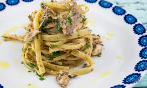 Un plat de pâtes linguine garni de sardines émiettées, de persil frais et de chapelure, un délice de pasta con le sarde.