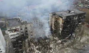 Zniszczone budynki mieszkalne, dym unoszący się nad gruzami, obraz tragedii, która rozpoczęła się, kiedy wybuchła wojna na Ukrainie.