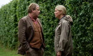 Två personer står och pratar intensivt framför en grön häck. Mannen bär kavaj och väst, kvinnan en jacka. En scen från en dansk kriminalserie på TV4.