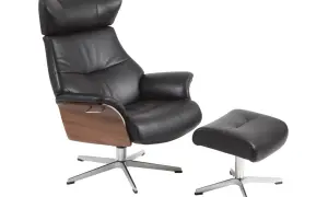 Svart läderfåtölj med fotpall, trädetaljer och metallunderrede. Perfekt för att koppla av i och känna conform air.