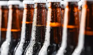 Bottiglie di birra ambrata, bagnate di condensa, perfette per chi cerca una birra piccola calorie.