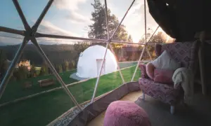 Widok z wnętrza kopuły na domek i otaczający krajobraz.