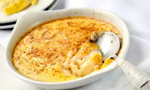 Un déliceux dessert crémeux, des oeufs au lait saupoudrés de cannelle, prêts à être dégustés avec une cuillère en argent.