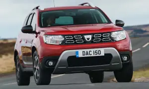 Röd Dacia Duster begagnad kör på en landsväg.