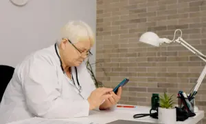 Lekarka sprawdza na telefonie, jak długo jest ważne skierowanie do szpitala.