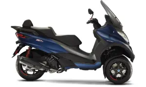 Niebieski Piaggio MP3 500, z trzema kołami, prezentuje się elegancko, choć jego wady mogą być dyskutowane.