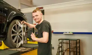 Mechaniker prüft die Spur am Auto.
