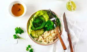 Un fresco e colorato cous cous freddo con avocado a spirale, cetrioli, lattuga e erbe aromatiche.