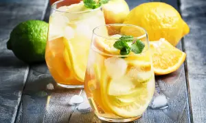 Två glas med uppfriskande vit sangria, fyllda med äppel- och citrusskivor, is och mynta. Perfekt för ett somrigt vit sangria recept.