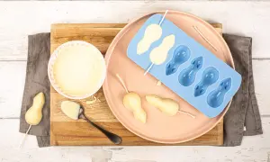 Préparation de **chocolat blanc** pour des souris en moule. Un bol de chocolat fondu, une cuillère, et des formes de souris en cours de fabrication.