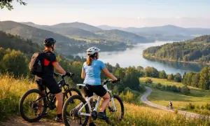 Para rowerzystów podziwia malowniczy krajobraz z jeziorem i wzgórzami. Idealne miejsce na odkrywanie tras rowerowych Podkarpacia.