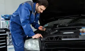 Mechanik wymienia żarówkę w Nissan Qashqai J10. Wymiana żarówki przód wymaga precyzji.