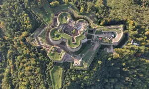 Fortyfikacje w kształcie gwiazdy otoczone lasem. Srebrna Góra oferuje unikalne atrakcje historyczne i widoki.