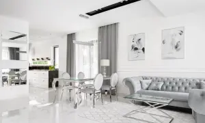 Eleganckie, nowoczesne wnętrze w stylu glamour. Błyszczące płytki, szara sofa i szklany stół tworzą luksusową atmosferę.
