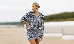 Kobieta o figurze klepsydry plus size w sukience w panterkę na plaży.