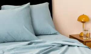 Soft, light blue sheets and pillows create a cozy bed. This material looks like the best material for sheets, promising comfort and style.