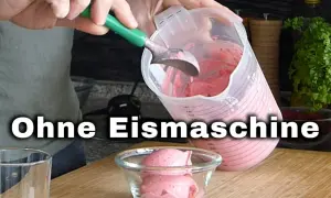 Joghurt Eis selber machen ohne Eismaschine: Eine Person füllt cremiges Erdbeer-Joghurt-Eis mit einer Eiskugel in eine Schüssel.