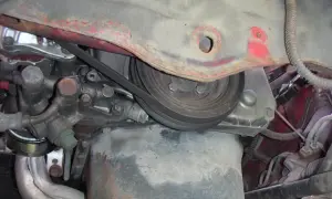 Detaljer från motorutrymmet, redo för kamkedja byte. Remmar och delar syns tydligt.