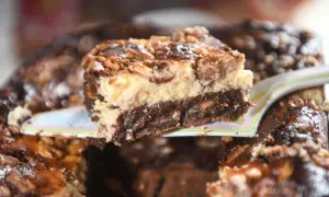 Ein Stück Schoko-Käsekuchen mit Walnüssen, der so gut aussieht, dass man ihn "friss dich dumm" nennen könnte.