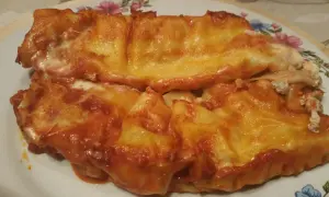 Cannelloni ricotta e carne gratinati al forno, con sugo rosso e formaggio filante.
